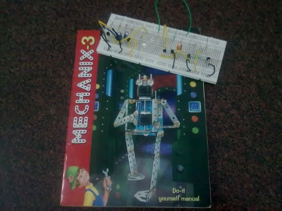 A "Mechanix-3" manual and a breadboard with a circuit on it